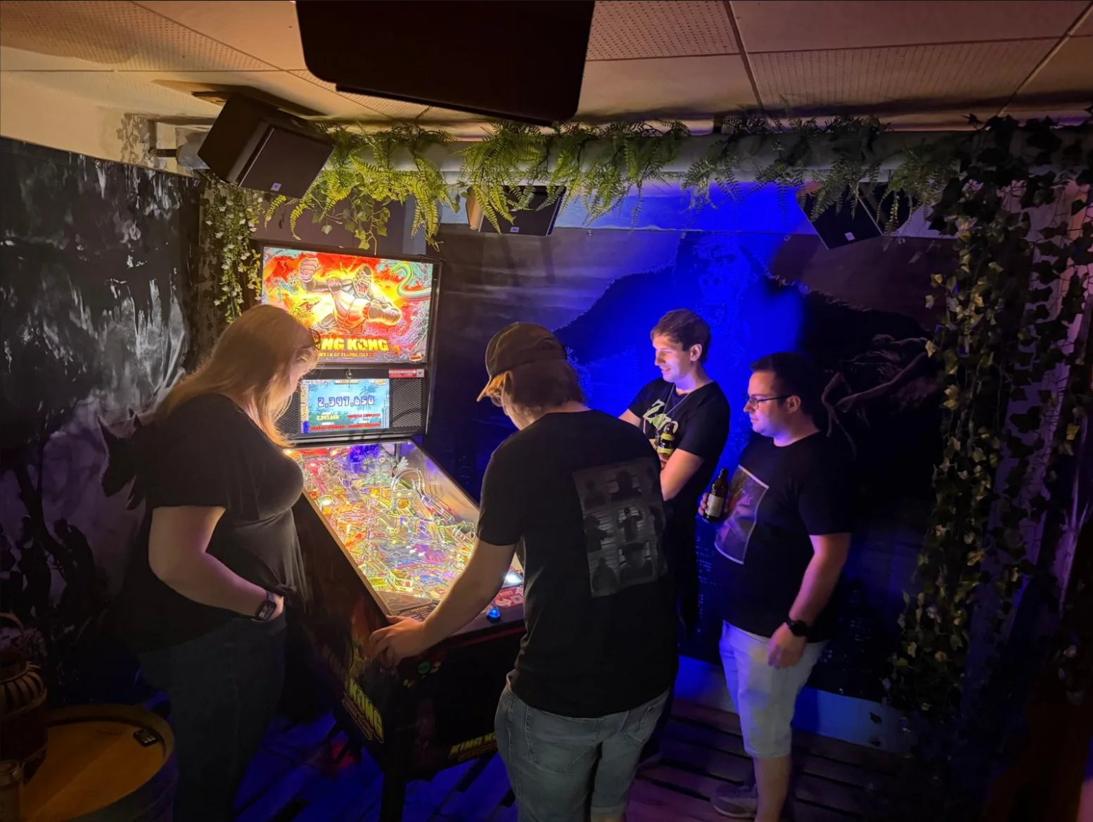 Gruppe spielt im King-Kong-Themenbereich an einem Flipper