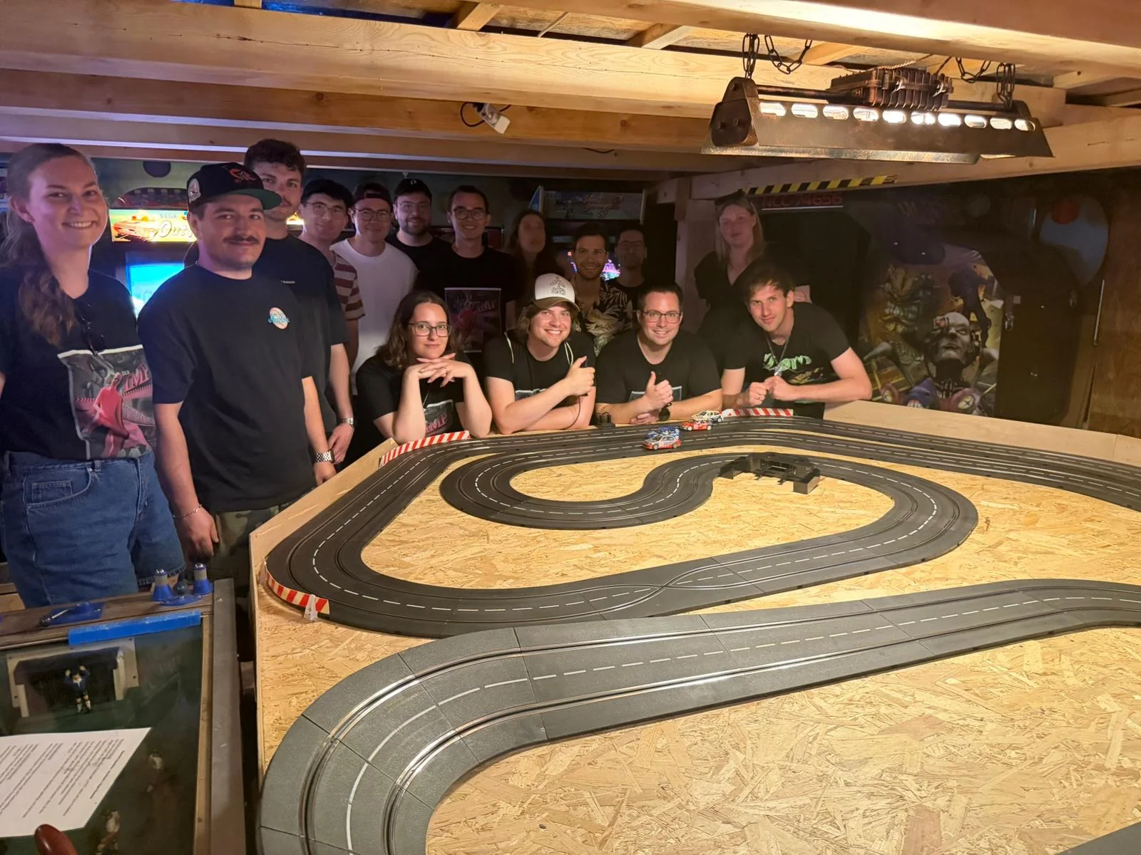 Gruppe steht gemeinsam an der Rennbahn im Flipperloft