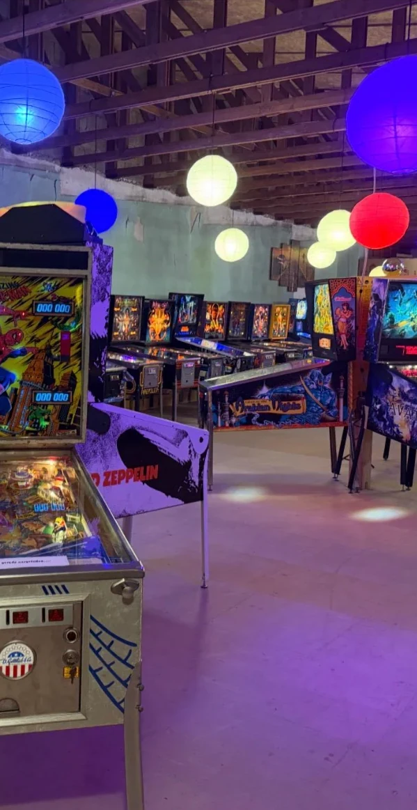 Flipperautomaten zwischen bunten Deckenlampen